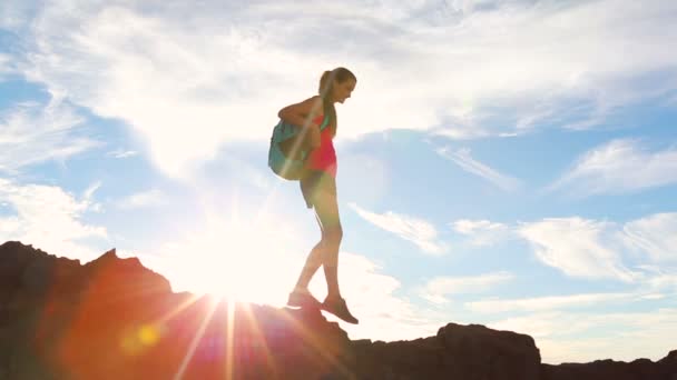 Senderista con Mochila Senderismo en la cima de una montaña con destellos de sol. Mujer joven y saludable aventura en la naturaleza . — Vídeos de Stock