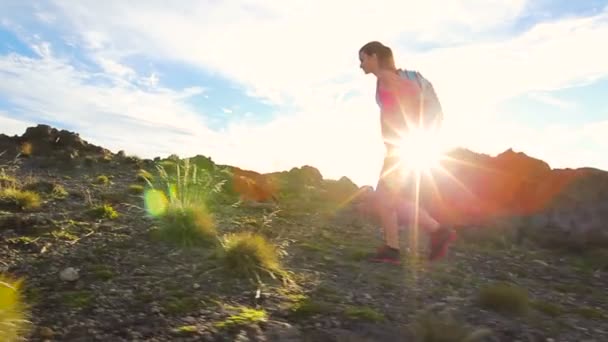 徒步旅行者背包徒步旅行太阳耀斑的山顶上。年轻健康的女性冒险性质. — 图库视频影像