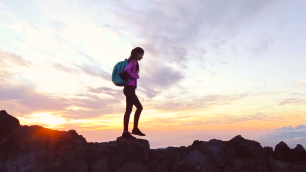 Wandelaar wandelingen langs de smalle top ridge crest bij zonsondergang. Bereiken van de Top. — Stockvideo