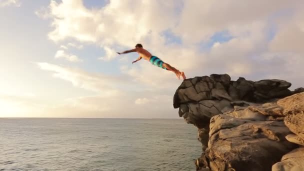 Klippa hoppa vid solnedgången i havet. — Stockvideo