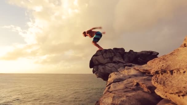 Estilo de vida al aire libre de salto de acantilado deportivo extremo de verano. Cliff saltando al atardecer . — Vídeos de Stock