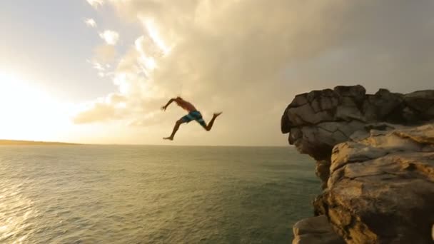 Cliff saltando al atardecer. Estilo de vida al aire libre de salto de acantilado deportivo extremo de verano. Cliff saltando al atardecer . — Vídeo de stock