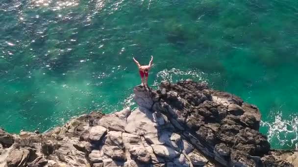 Vista aérea acantilado saltando en el océano azul. Estilo de vida de deportes de acción de verano. Joven salta desde el acantilado en cámara lenta . — Vídeo de stock