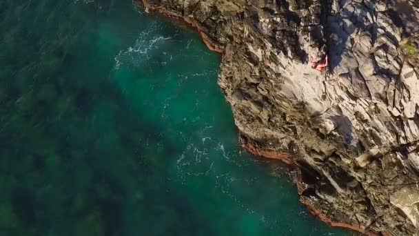 Aerial View Cliff Jumping into Blue Ocean. Summer Action Sports Lifestyle. Young Man Jumps off Cliff in Slow Motion. — Stock Video