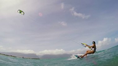 Bikini 'de okyanusta uçurtma uçuran genç bir kadın. POV GOPRO Yavaş Hareket. Yaz Eğlencesi Ekstrem Spor.