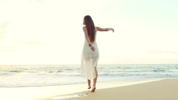 Щаслива дівчина веселяться на пляжі на розкішному острові на заході сонця. Повільний рух — стокове відео