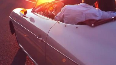 Mutlu çift klasik Vintage spor araba batımına ülke yolda sürüş