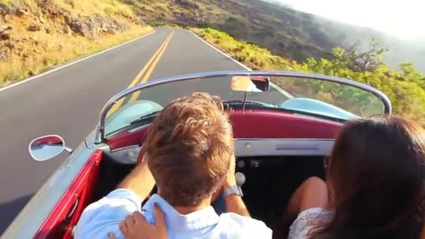 Pareja feliz conduciendo por Country Road hacia el atardecer en el clásico coche deportivo vintage — Vídeos de Stock