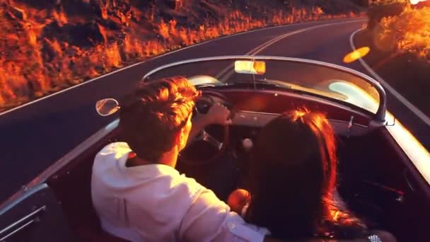 Couple heureux conduisant sur la route de campagne dans le coucher du soleil dans la voiture de sport classique Vintage — Video