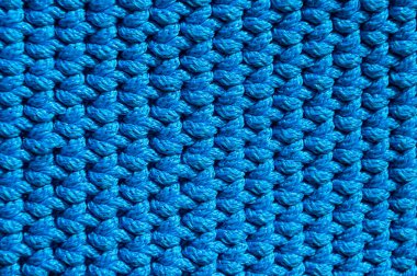 Polimer kablodan yapılmış örülmüş mavi halının arka plan dokusu merkezde seçici bir odak ile yakın plan görüntüsü..
