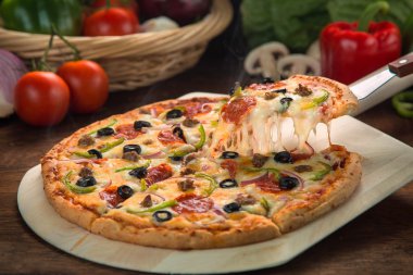 Tam yüce pizza malzemeleri yanında fırın dışında taze pişmiş lezzetli peynir kılçıklı dilim kaldırdı