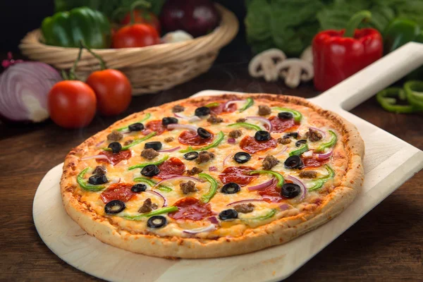 Delicioasă pizza supremă Deluxe coaptă proaspăt din cuptor lângă ingrediente — Fotografie, imagine de stoc