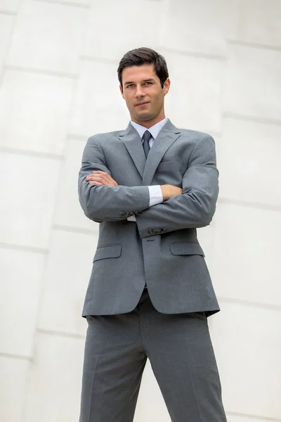 Tiro vertical de confianza hombre de negocios joven adulto brazos cruzados en poderosa pose de pie —  Fotos de Stock