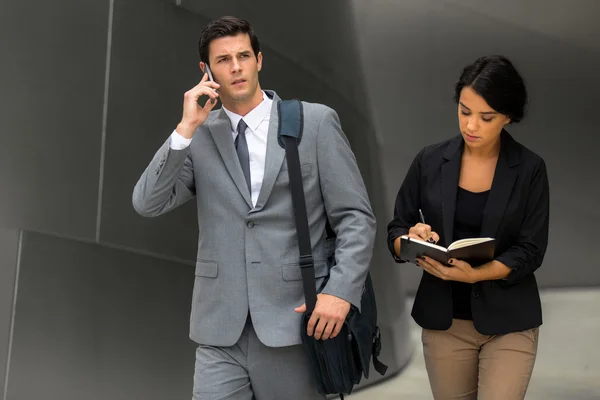 Очень занятый бизнес-менеджер на ходу с помощником по мобильному телефону — стоковое фото