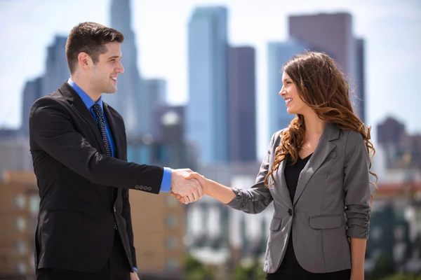 Maschio e femmina business coppia leader di gruppo stringendo la mano centro città — Foto Stock