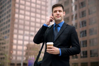 İşadamı kahve etkin yönetici arama cellphone ile kahve etkin yönetici arama şehirde yürüyüş elbiseli citybusinessman içinde yürürken bir takım ile cep telefonu üzerinde