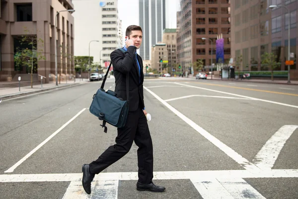 Businessman crossing the street crosswalk on way to work fast paced with cellphone — Stock Photo, Image