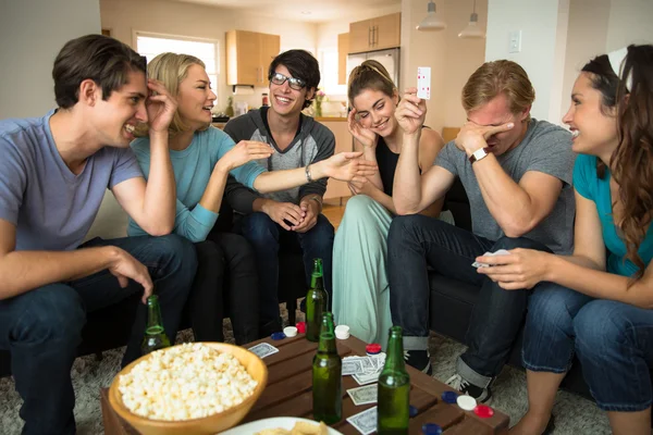 Game night poker playing friends loser embarrassed and winner celebrates at party