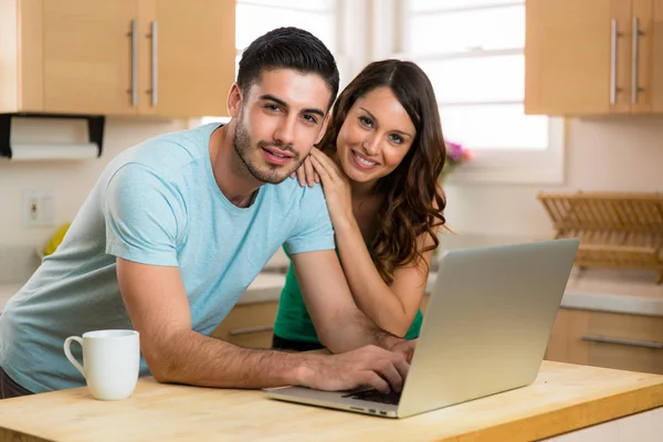 Esposo y esposa pareja compartiendo una computadora portátil red social riendo sonriendo en busca de contenido divertido con café —  Fotos de Stock