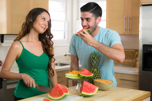 Man eats watermelon handsome boyfriend stealing bite kitchen from wife fruit — Zdjęcie stockowe