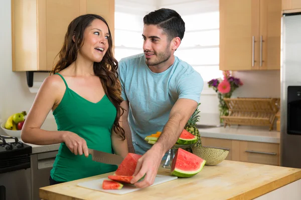 Spielerisches Paar Lebensstil Schneiden von Obst und Gemüse Wassermelone lachen in der Küche — Stockfoto