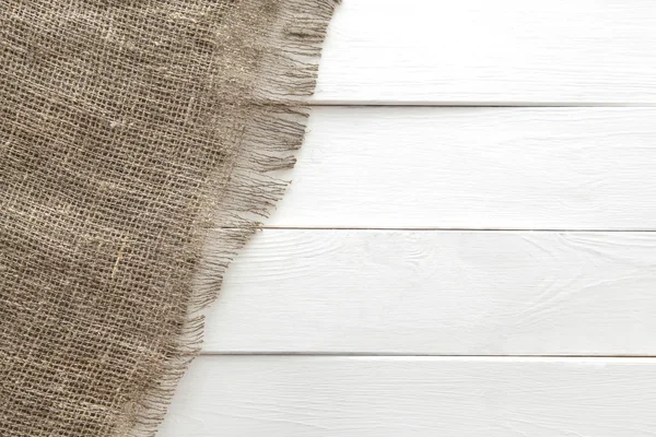Textura de arpillera sobre fondo de madera blanca — Foto de Stock