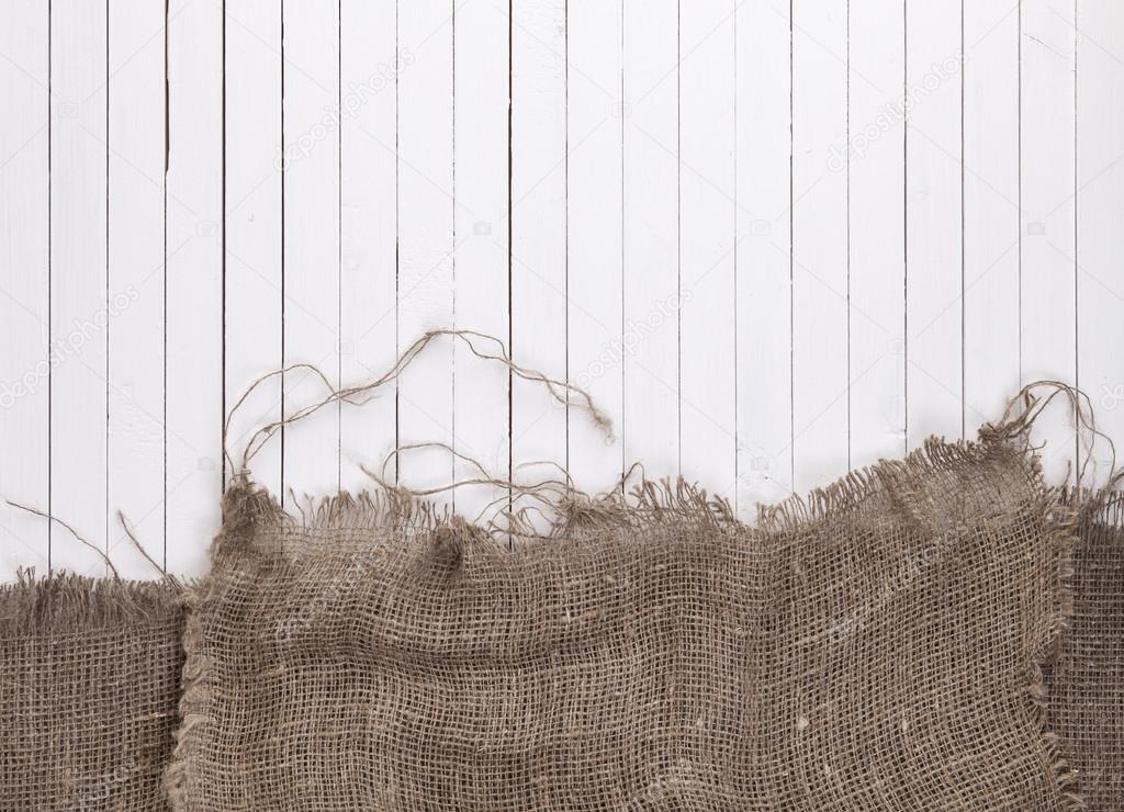 Burlap hessian or sacking on white wooden background