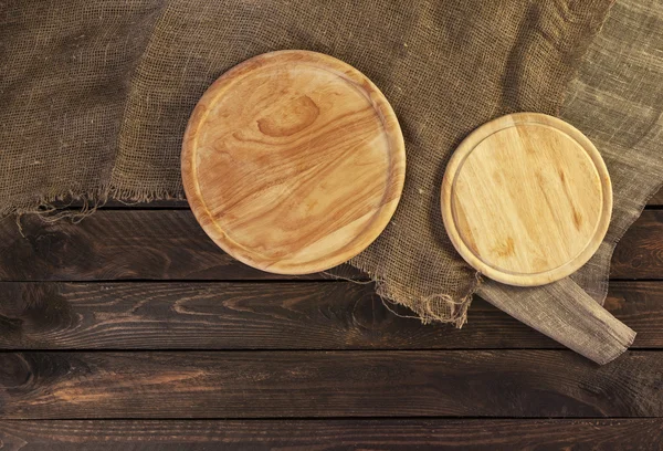 Tabla de cortar redonda sobre mesa de madera oscura — Foto de Stock