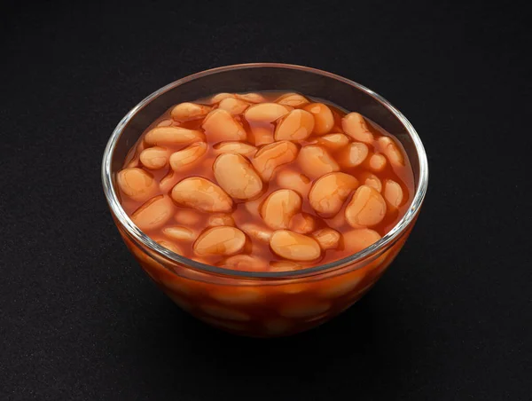 Frijoles al horno en salsa de tomate sobre fondo negro —  Fotos de Stock