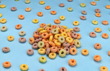 Mavi arkaplanda renkli mısır halkaları yığını