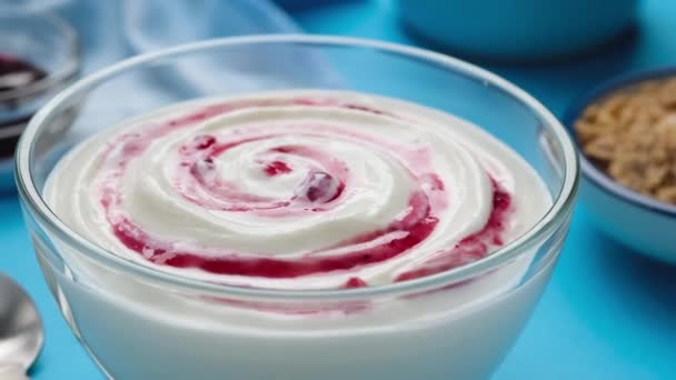 Yoghurt met bessenjam, bosbessenslagroom — Stockvideo