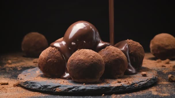 Chocolate pouring on truffles, melted chocolate icing on black slate — Stock Video