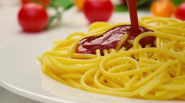 Spagettiye ketçap dökülüyor, makarnaya domates sosu dökülüyor, yavaş çekim.