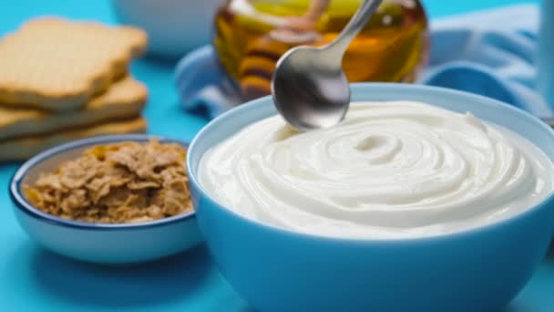 Miska kwaśnej śmietany na niebieskim tle, jogurt grecki — Wideo stockowe