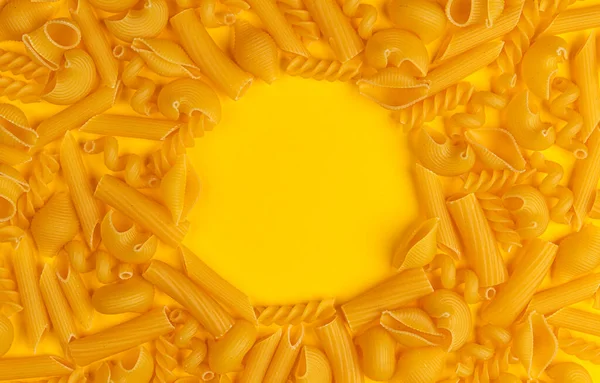 イタリアのパスタパターン、黄色の背景に異なるパスタタイプ、フラットレイ — ストック写真