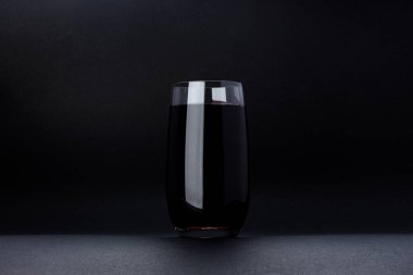 Siyah arka planda izole edilmiş bir bardak kiraz suyu ve fotokopi alanı. Taze meyve suyu, kiraz kokteyli, sağlıklı içecek konsepti, yakın plan.