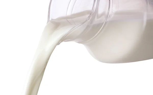 用白色底色分离出来的水花从壶中倒入牛奶 — 图库照片