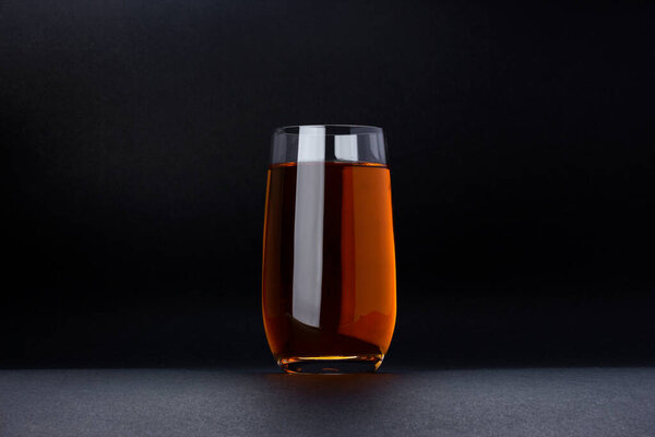 Glass of apple and grape juice on black background with copy space