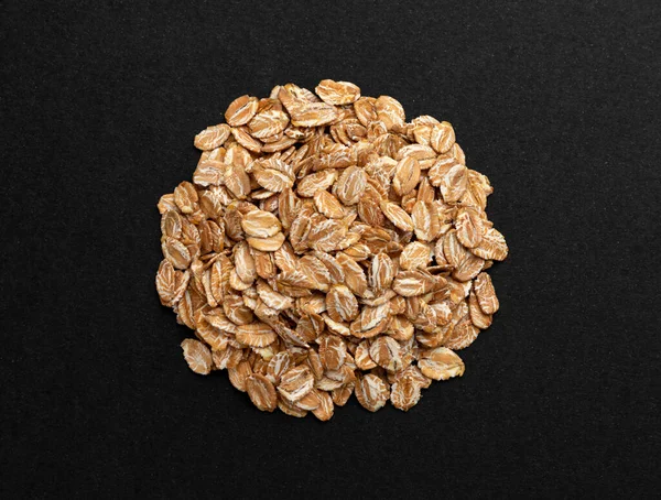 Top view of oat flakes on black background — Stock Photo, Image