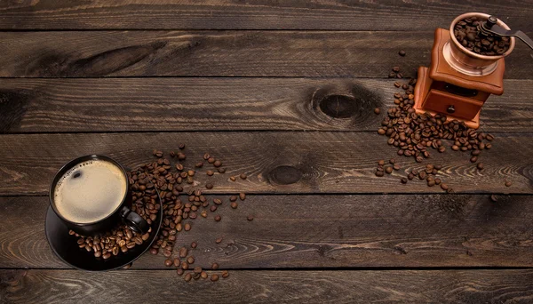 Taza de café y molinillo en mesa de madera —  Fotos de Stock