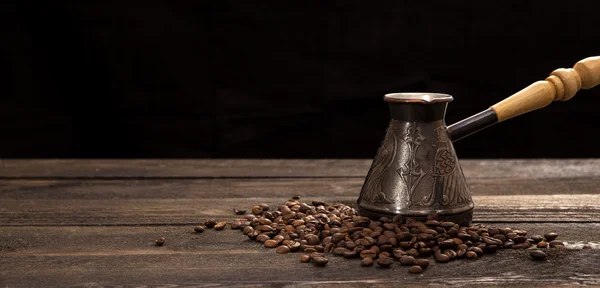 Cafetera con granos de café sobre fondo de madera —  Fotos de Stock