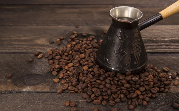 Кавоварка з кавовими зернами на дерев'яному фоні — стокове фото