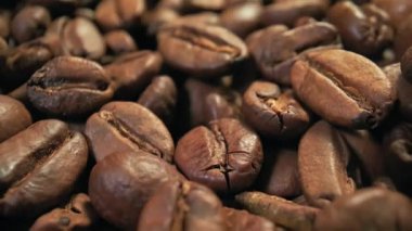 Taze kavrulmuş kahve çekirdekleri yakın çekim, yavaş çekim, üst manzara.