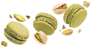 Beyaz arka planda tamamen izole edilmiş fındıklı fıstıklı badem kurabiyeleri uçuşuyor.