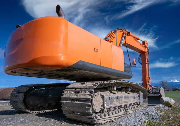 orange crawler excavator on the construction site. Clearing, grading, excavation of trenches, and of foundations. Earth moving machinery.