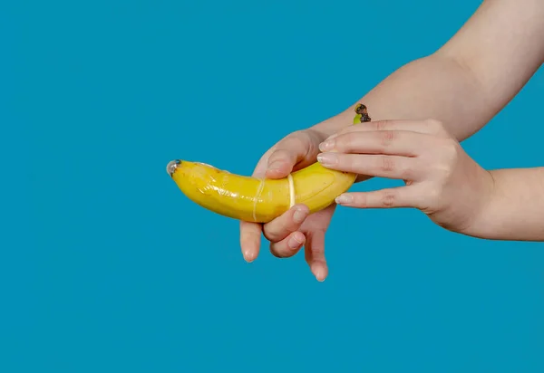 Жінка Кладе Презерватив Банан Концепція Сексу Безпеки Синьому Фоні — стокове фото