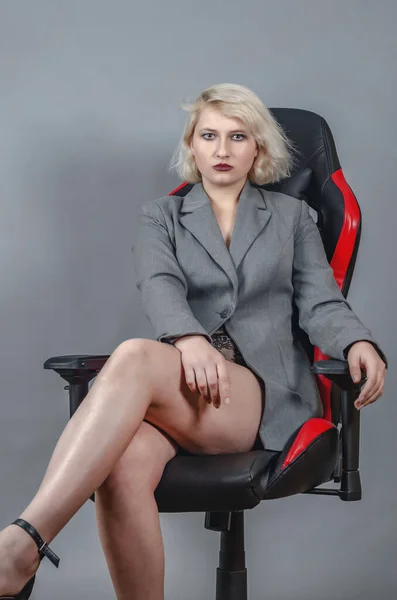 Молода Жінка Сірому Піджаку Сексуально Сидить Офісному Ігровому Кріслі Сірому — стокове фото