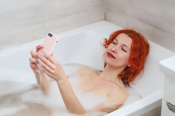 화장실에 휴대폰을 여자가 전화로 메시지를 전화를 있습니다 — 스톡 사진