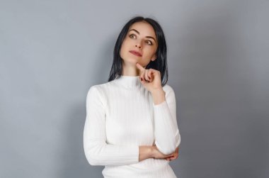 Beyaz kazaklı güzel kadın kameraya bakıyor. Başarılı iş kadınının portresi