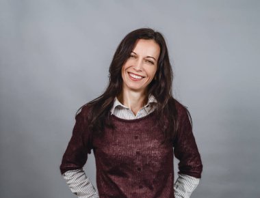 Gri arka planda sevimli, gülen kadın portresi